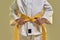 Cropped shot of little karate girl in white kimono adjusting yellow belt while getting ready for exercising, doing