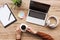 cropped shot of man with cup of coffee at workplace with laptop, headphones, blank notepad