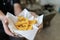 Cropped shot of man hand holding bowl of french fries fast food in bucket with copy space, close up