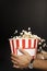 cropped shot of man holding cardboard bucket of popcorn