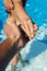 cropped shot of man holding hand of wife in swimming pool follow