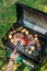 cropped shot of man with tongs cooking food on grill during barbecue