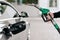 Cropped shot of mans hand pumping gasoline fuel in car at gas station. Auto being filled with petrol. Unrecognizable man holds