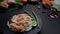 Cropped shot of papaya salad on black plate, chicken grill on green taro and ingredients