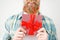 Cropped shot of romantic bearded male holds present box in front, going to make surprise for girlfriend, isolated on