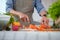 Cropped shot senior man chopping fresh carrot on board preparing a healthy salad in kitchen