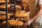 cropped shot of shop assistant arranging loafs of bread