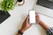 Cropped shot top view of businessman hands using smartphone mockup on office desk. Blank screen mobile phone for graphic display