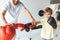 cropped shot of trainer holding hands of boys in boxing gloves