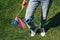 cropped shot of woman in denim with american flagpole in hand standing on green grass, 4th july