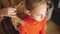 Cropped shot of woman doing hairstyle to serious girl