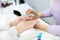 Cropped shot of woman manicurist filing and shaping nails of client