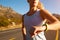 Cropped shot of woman running and checking her sports watch