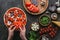 Cropped shot of woman spreading bell pepper slices onto pizza