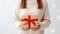 cropped shot of woman in white sweater holding christmas gift box Generative AI