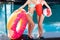 cropped shot of women with inflatable ring in shape of bitten donut and beach ball standing