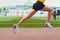 Cropped shot of young female athlete launching off the start line in a race. Female runner started the sprint from the