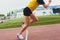 Cropped shot of young female athlete launching off the start line in a race. Female runner started the sprint from the