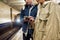 Cropped shot of young people using smartphones while waiting for the train at the subway metro station. Couple of