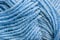 Cropped skein of pale blue woolen knitting thread texture. Ball of soft woolen yarn full frame macro photography. Knitting threads
