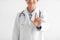 Cropped smiling millennial indian female doctor in coat showing finger up, hand gesture