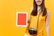 Cropped tourist woman holding tablet pc computer with blank black empty screen isolated on yellow orange background