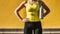 Cropped unrecognizable female athlete standing with water bottle while taking break from training in bright sunlight concrete