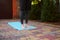 Cropped view of an active man, sportsman, yogi standing barefoot on a blue fitness mat while practicing yoga outdoors