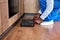 Cropped view of afro black workman in blue overalls opening toolbox on kitchen floor