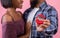 Cropped view of black couple holding box with engagement ring on pink studio background, panorama