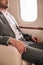 cropped view of businessman sitting in plane near airplane window.