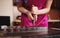 Cropped view of chocolatier pouring chocolate filling into chocolate mold preparing luxurious handmade pralines