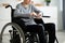 Cropped view of disabled teen boy in wheelchair using smartphone at home, closeup