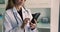 Cropped view female doctor using smartphone at workplace