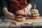 cropped view of girl in apron making homemade cheeseburgers on baking paper