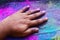 Cropped view of hand with multi-colored Holi powder background