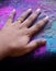 Cropped view of hand with multi-colored Holi powder background