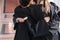 Cropped view of interracial graduates hugging