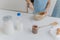 Cropped view of kid in apron whisks ingredients in bowl with beater, busy cooking and helping mother to prepare cake. Dough, milk