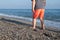 Cropped view of little boy walking on lonely beach. Child standing on sand beach