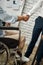 Cropped view of male office worker in a wheelchair shaking hand to his colleague while working together in the creative