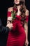 cropped view of man presenting rose to woman in red dress isolated