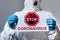 Cropped view of mature doctor in hazmat suit holding placard with stop coronavirus lettering