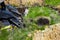 Cropped view of mini loader digging pit during earth works on grassy field