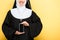 Cropped view of nun presenting smartphone with blank screen