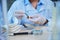 Cropped view of a scientist holding PH indicator strip, litmus or reagent paper for measuring alkalinity and acidity.