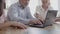 Cropped view of senior businessman typing on laptop keyboard