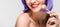 Cropped view of smiling nude girl in purple wig holding sweet lollipop