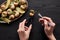 Cropped view of woman eating delicious escargots with lemon on black wooden table.