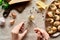 Cropped view of woman eating escargots with tweezers near lemon slices, Parmesan, garlic, parsley, black peppercorn on